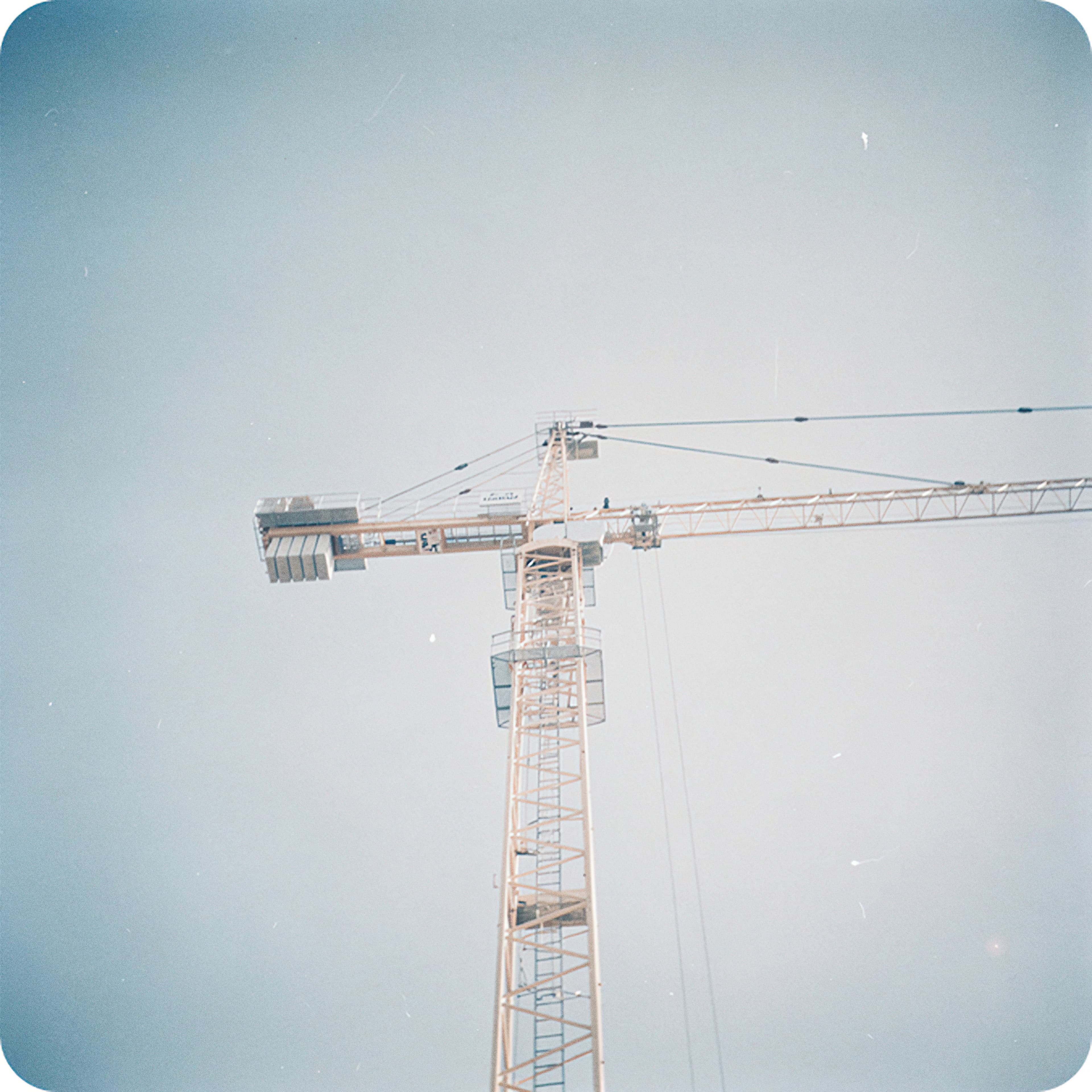 Tower crane against a pale sky, representing construction