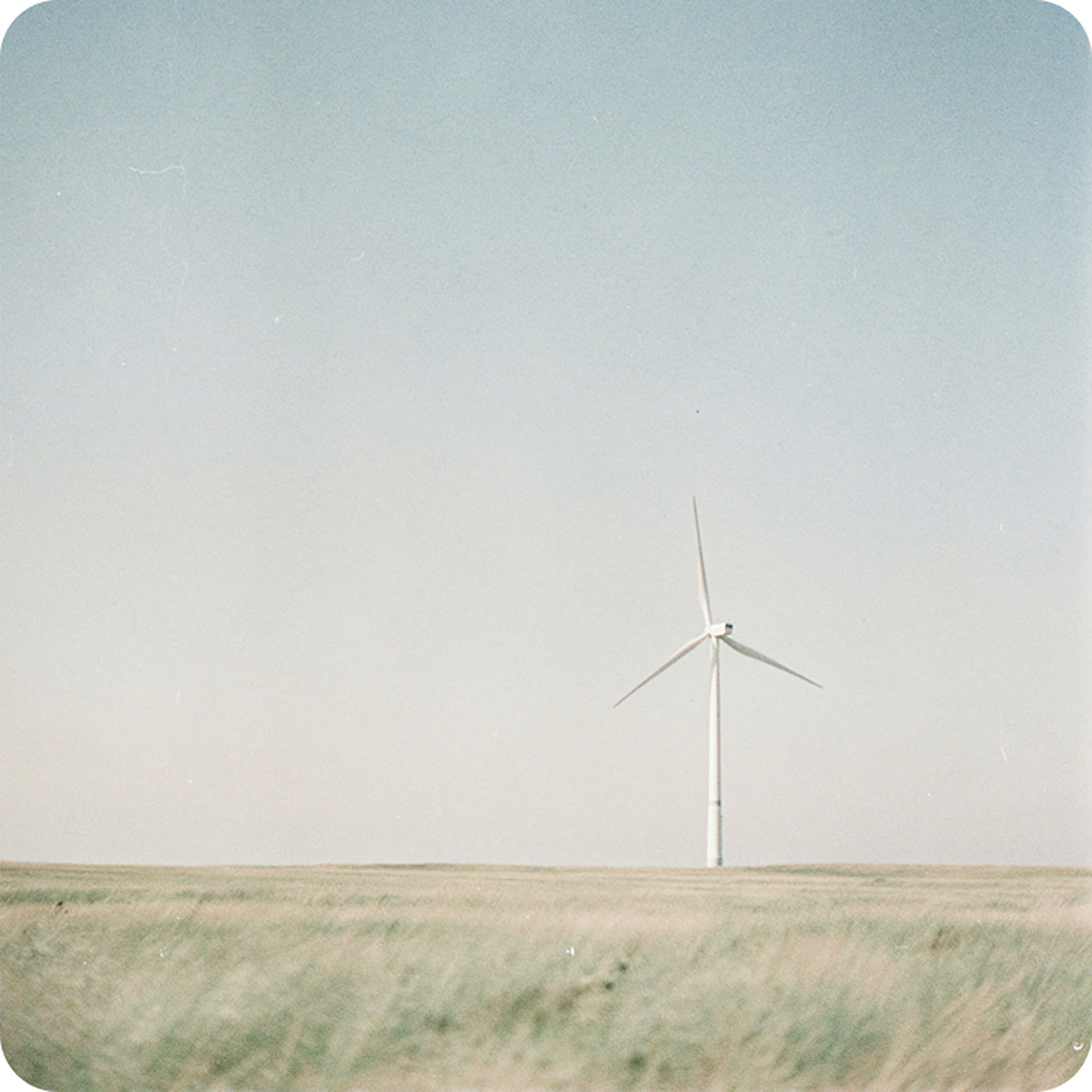 Single wind turbine on open grassland, representing energy